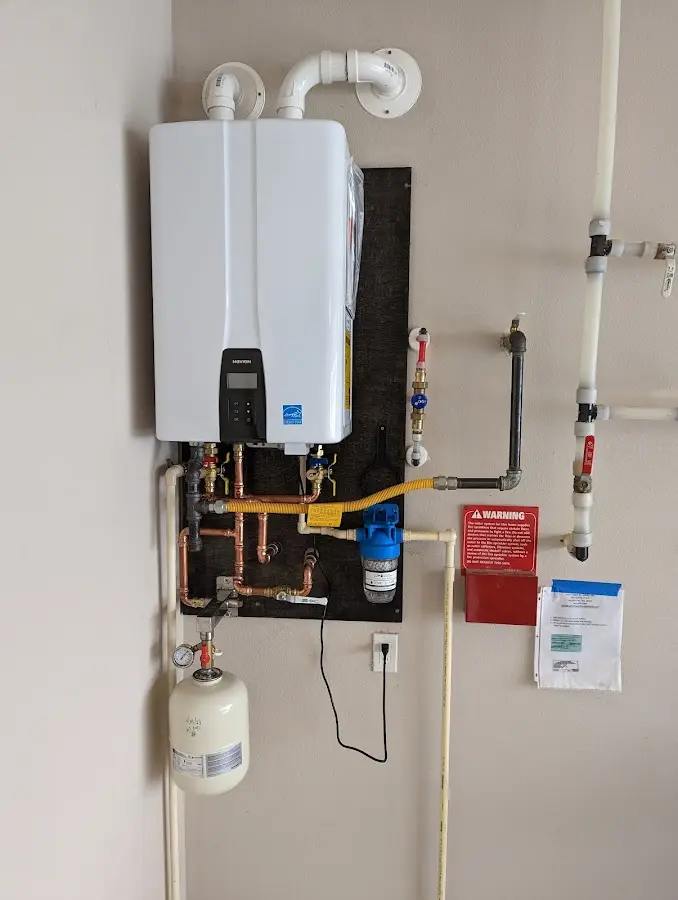 Professional plumber installing copper piping in a Newton home